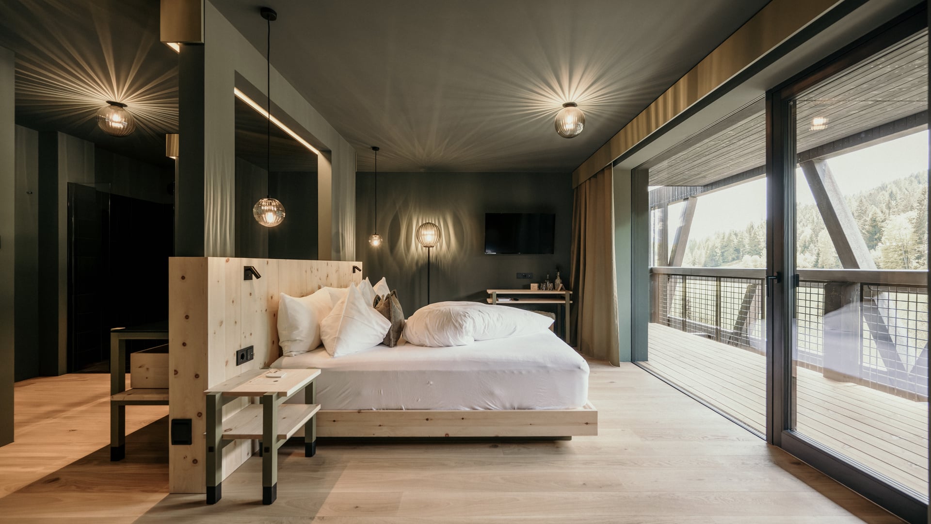 Living surrounded by the nature of the Dolomites Naturzimmer Pinus room with natural wood furnishings and view of the Dolomites